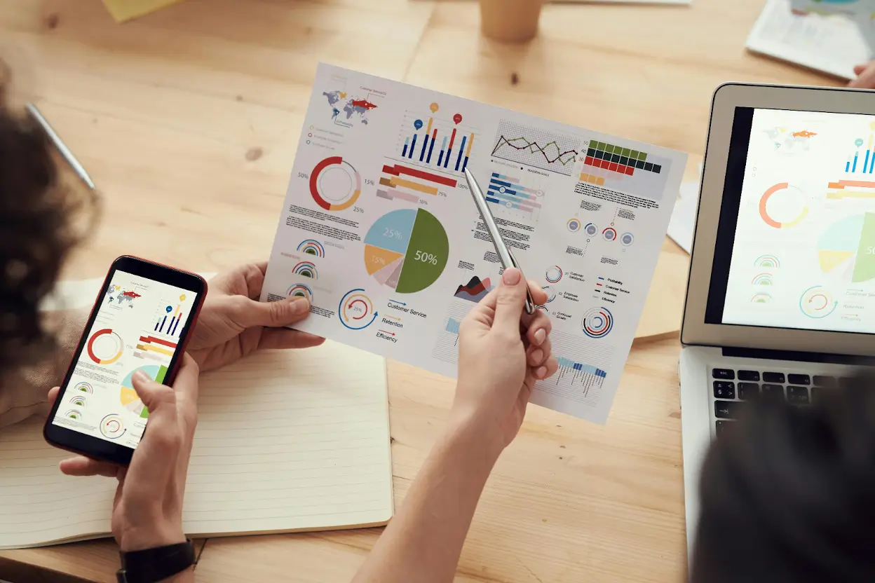 Business professional reviewing charts on printed reports