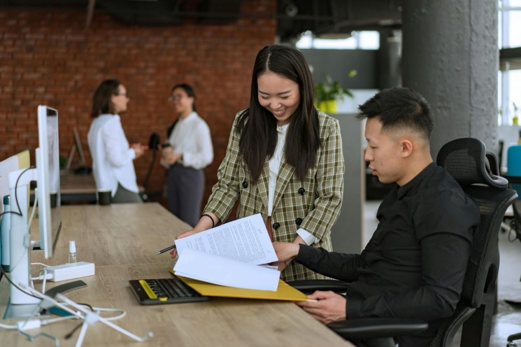 Two financial professionals having a discussion while reviewing documents together