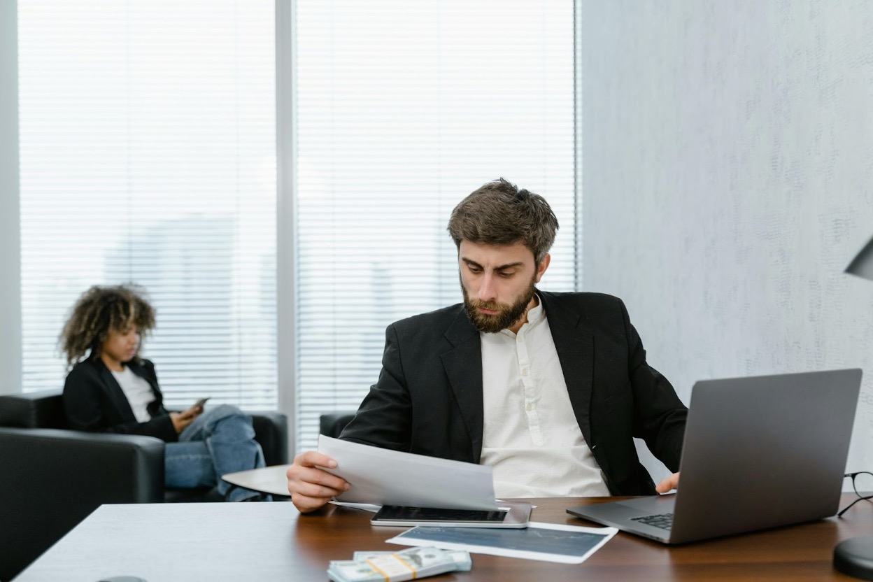 Business professional analyzing debt collection reports and financial data on a laptop