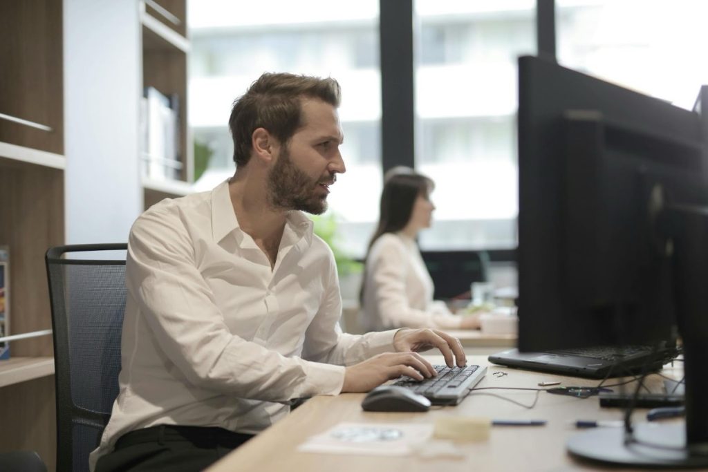 Collection specialist using computer software to verify debtor contact information.