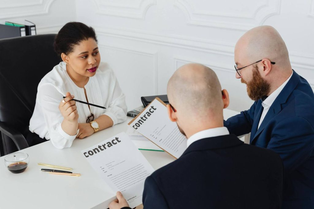 Business professionals reviewing and signing a commercial lease agreement.