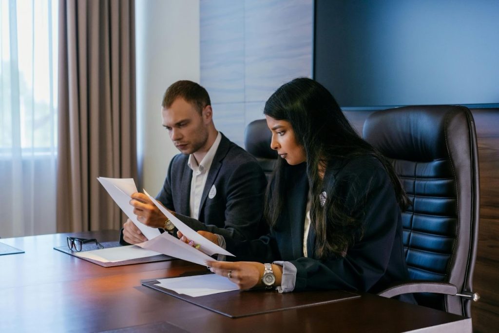 Business professionals reviewing collection agency credentials and performance metrics in a conference room