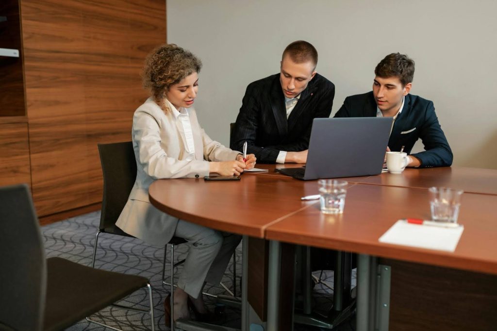 Business team reviewing collection agency proposals at conference table.