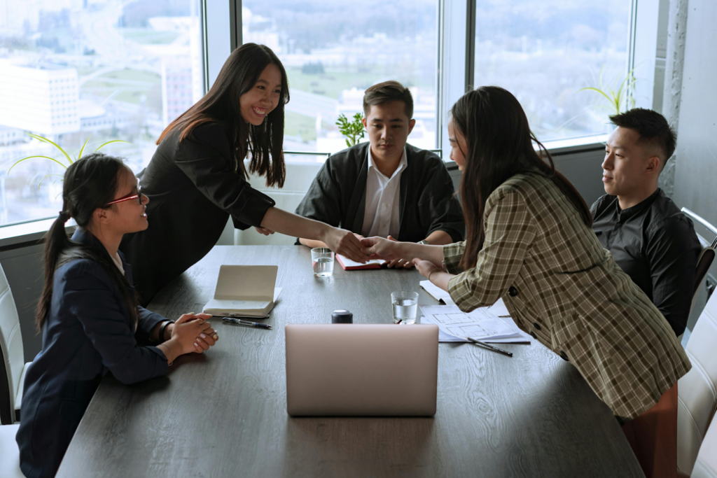 Five business professionals engaged in a meeting at a conference table