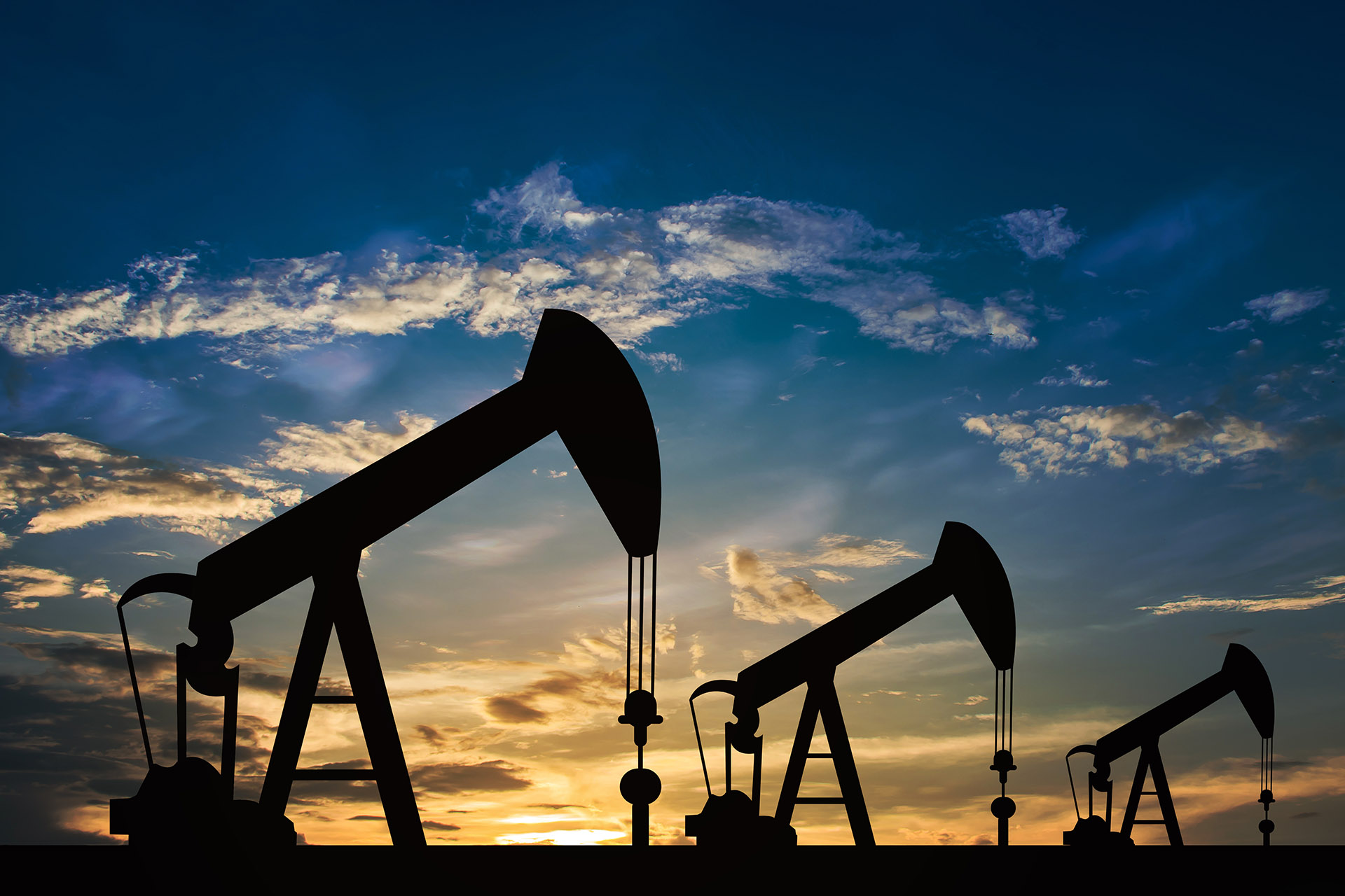 Silhouetted oil pumps at sunset